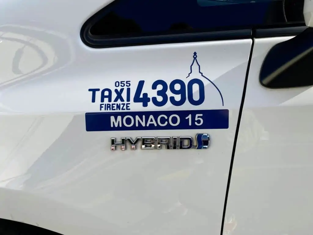 close up of taxi call sign on the side of a white florence taxi