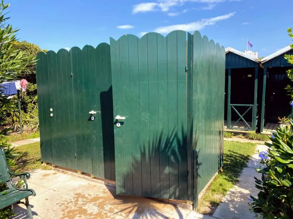 green showers at an italian bagno, with green beach changing cabanas in the back on the right