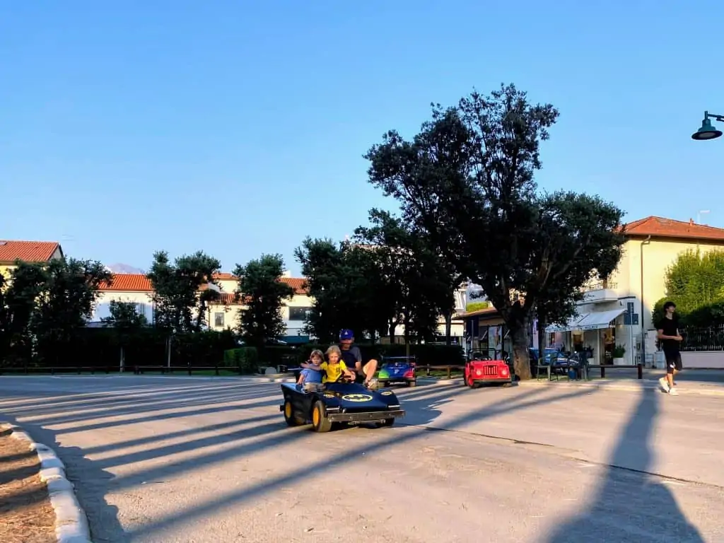mini car with kids and father going around the track in forte dei marmi, italy