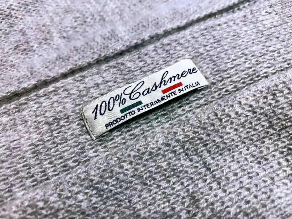 grey cashmere with a close up of the label that says 100% cashmere - prodotto interamente in italia