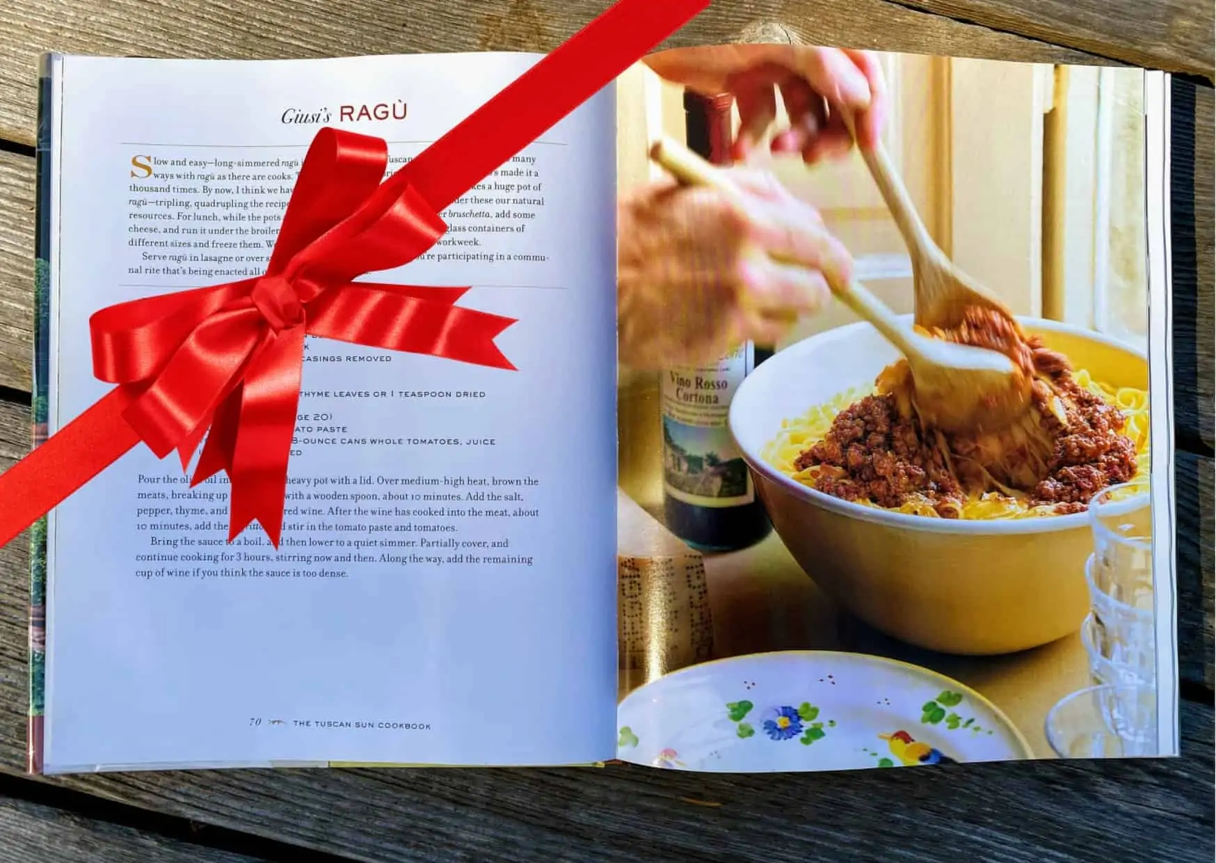 Red ribbon on top of the Tuscan Sun Cookbook open to a ragu recipe and its accompanying photo.