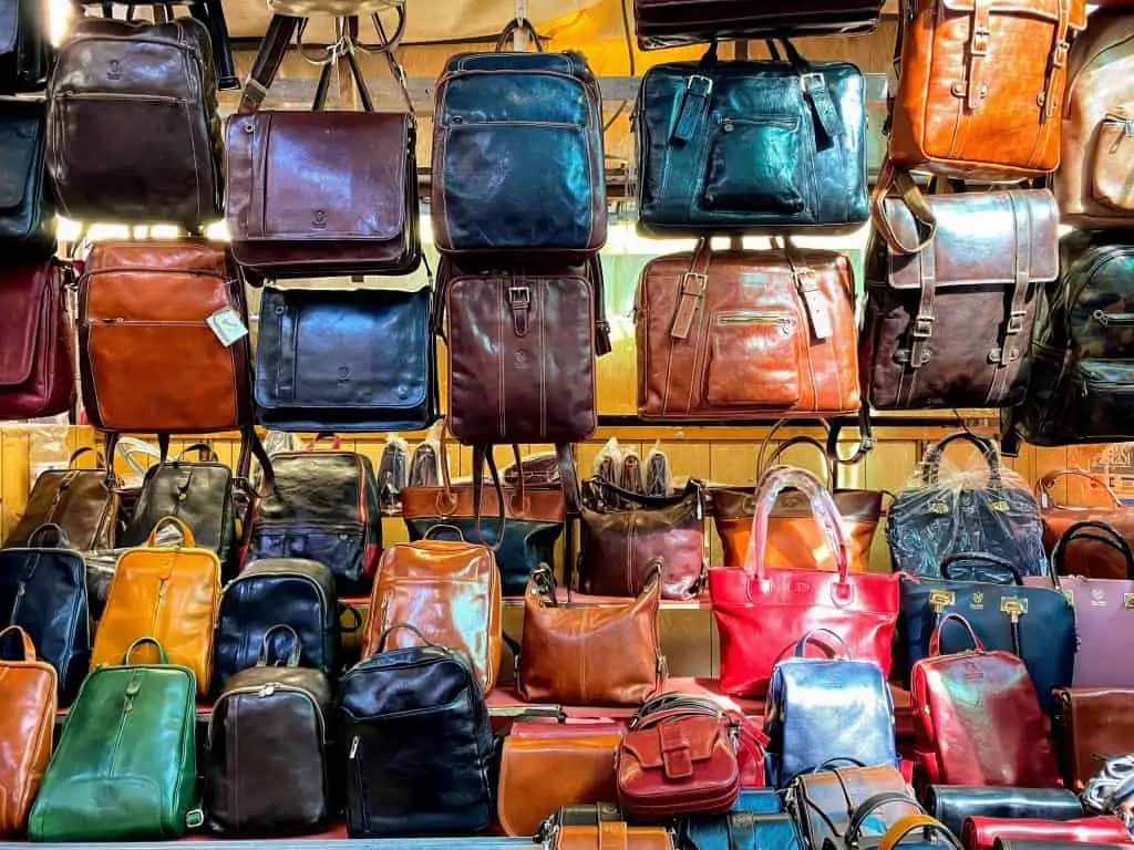 Colorful display of leather bags on a wall display at the Mercato del Porcellino in Florence, Italy.