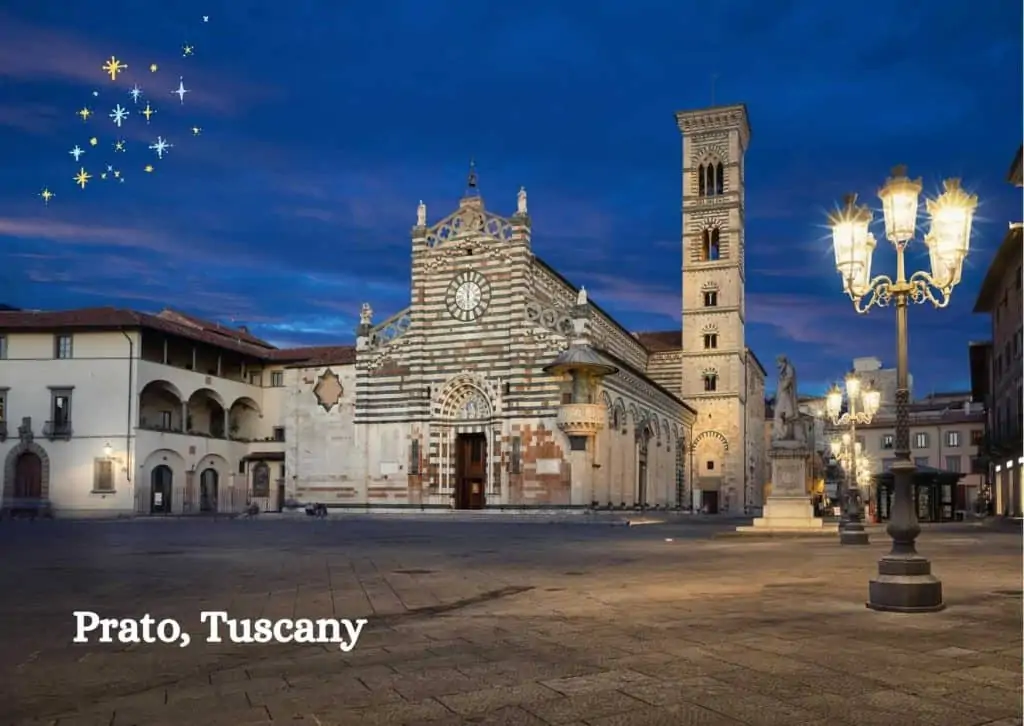 Main square in Prato, Tuscany, Italy.  It's nighttime and there are streetlamps on on the right side of the photo.