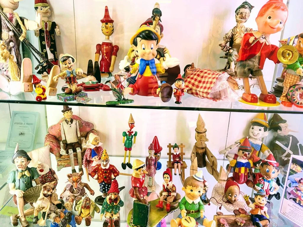 Window display from the museum at the Pinocchio Park in Collodi, Tuscany.  There are different versions of Pinocchio figurines.