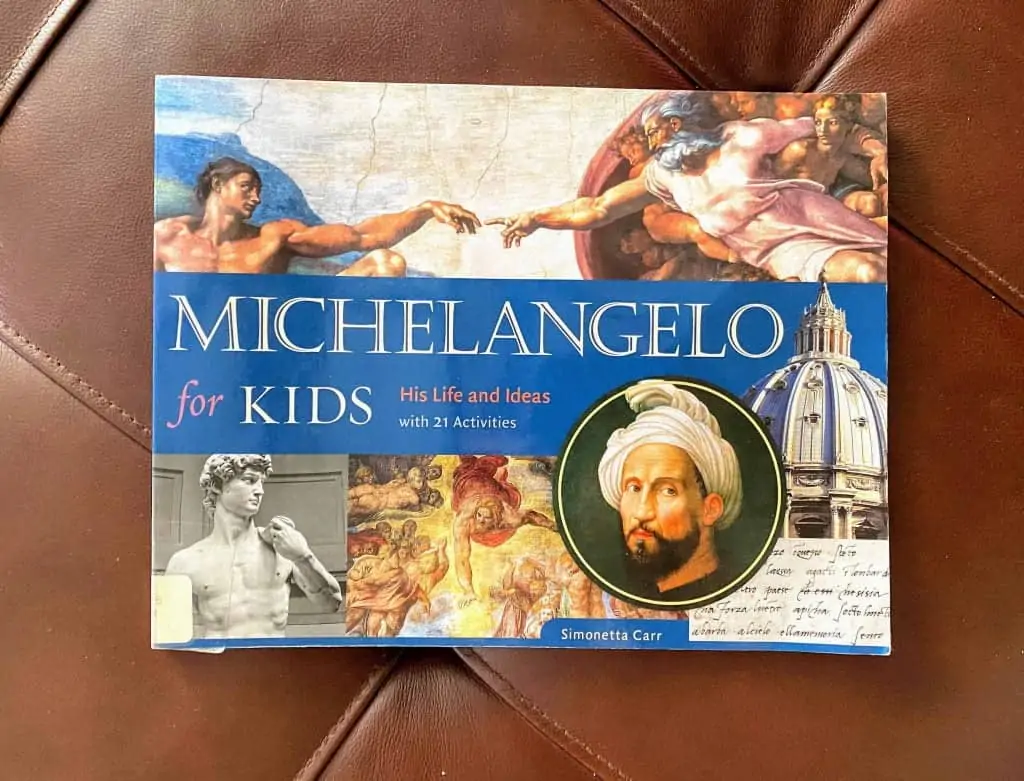 Michelangelo for Kids book sitting on a brown leather couch cushion.