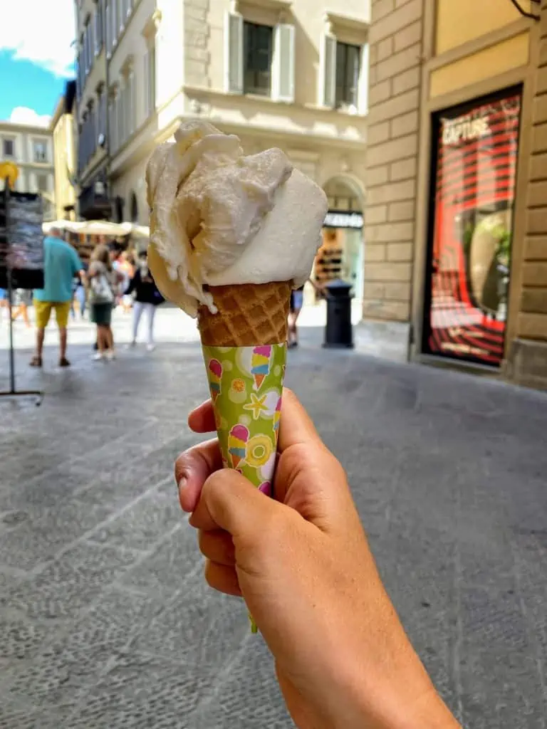 Gelato cone held up in the center of Florence, Italy.