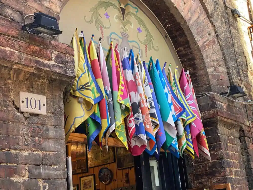 Flags of Siena, Italy's contrade hang above a storefront.
