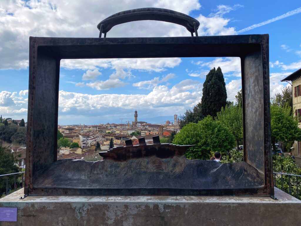 Skyline of Florence framed by metal sculpture in the Rose Garden (Giardino delle Rose). Sunny day with puffy white clouds.