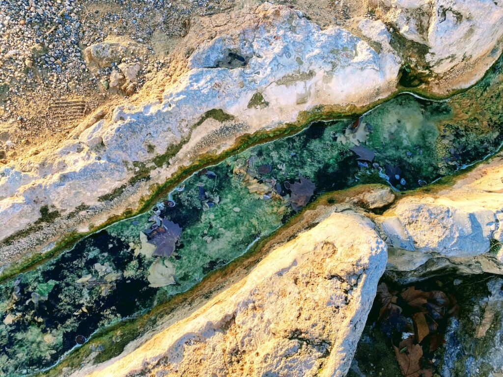 Turquoise streem flows between rocks.