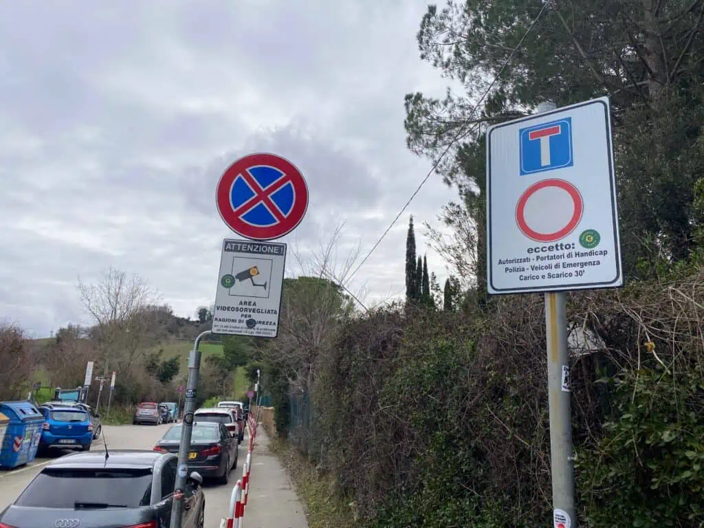 'No parking' and 'do not enter' signs on the small road in front of the Saturnia hot springs in southern Tuscany, Italy.
