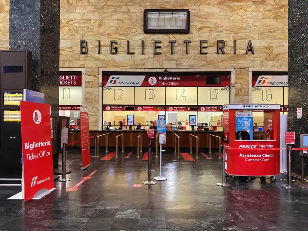 Ticket counters at the Florence Santa Maria Novella train station in Florence, Italy.  You can see numbered booths with ticket agents.