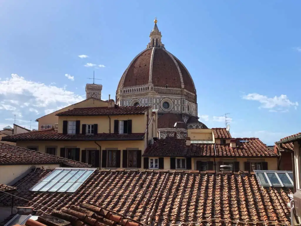 Close up view of the dome of the Duomo in Florence, Italy. You can also see some rooftops and building upper floors.