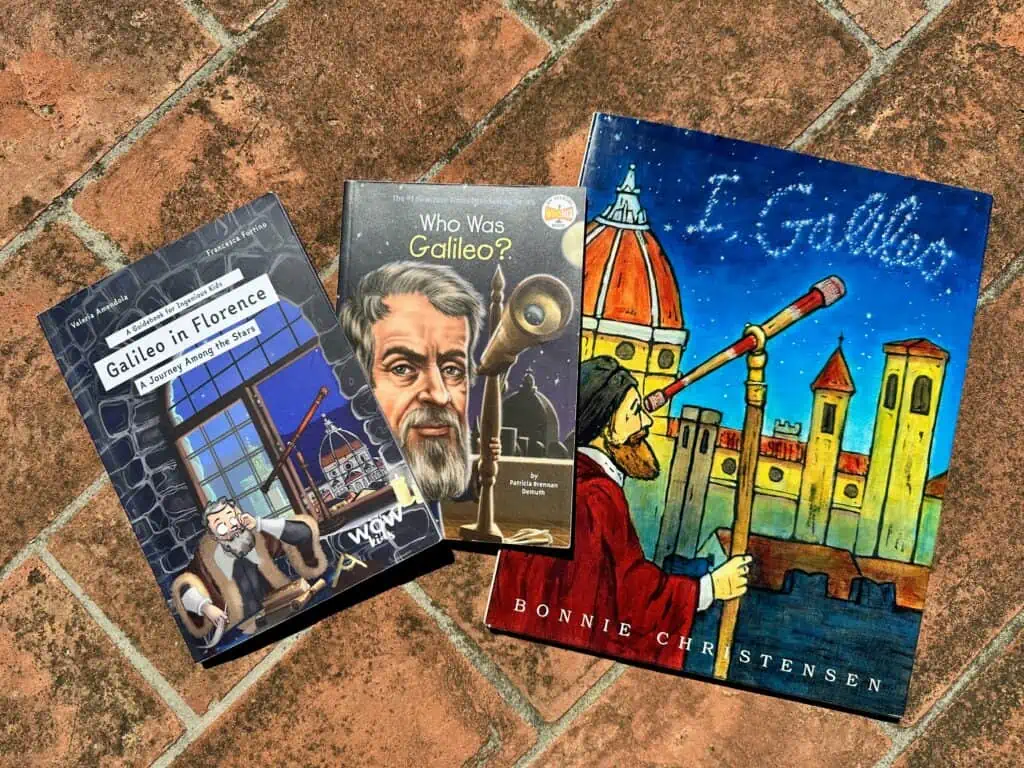 Three Galileo books spread out on a terracotta surface.