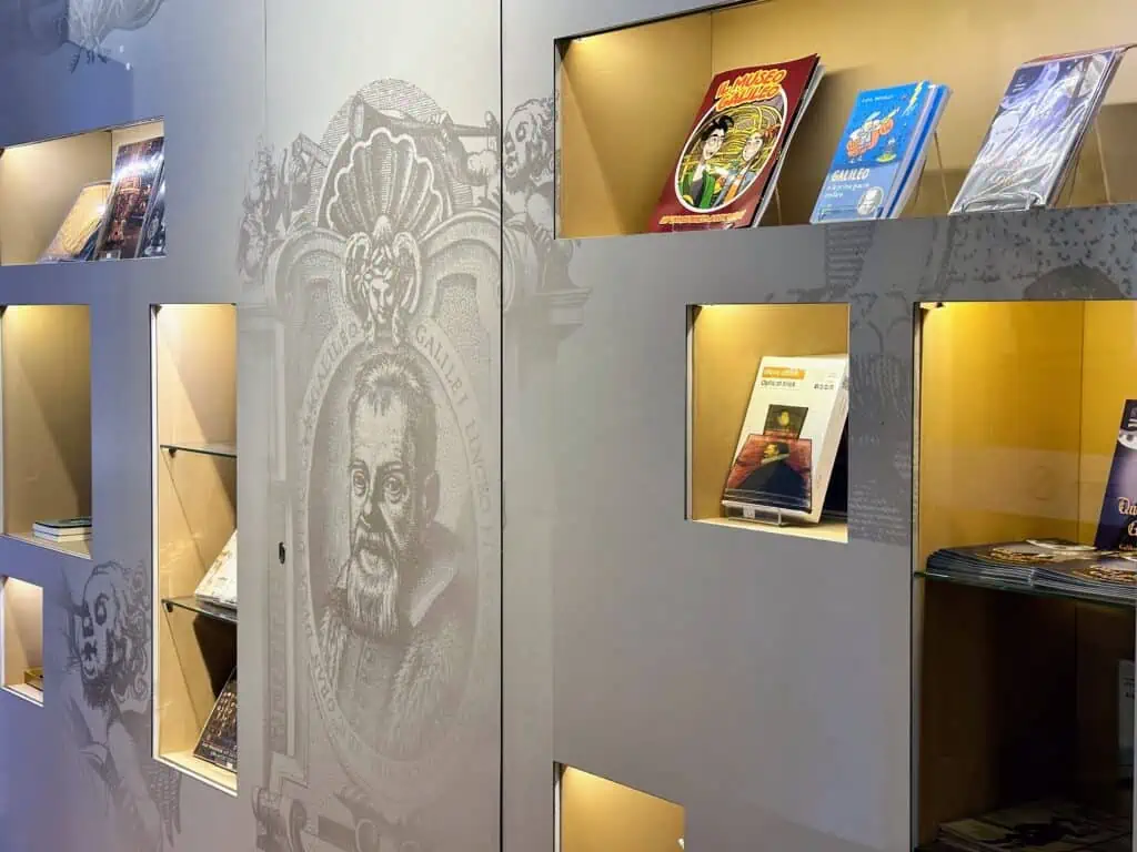 Wall display in bookshop in Galileo Museum in Florence, Italy.  You can see a grew wall and glass cases with Galileo books for kids and adults on display.