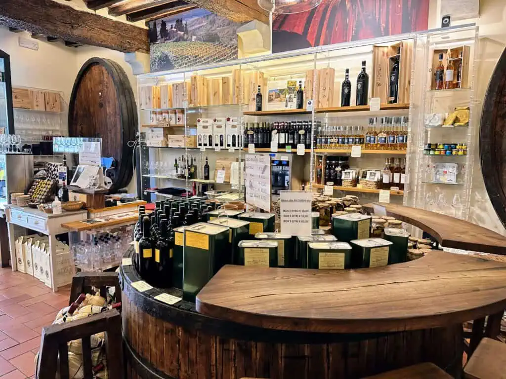 Wine and olive oil bottles on display inside an enoteca.