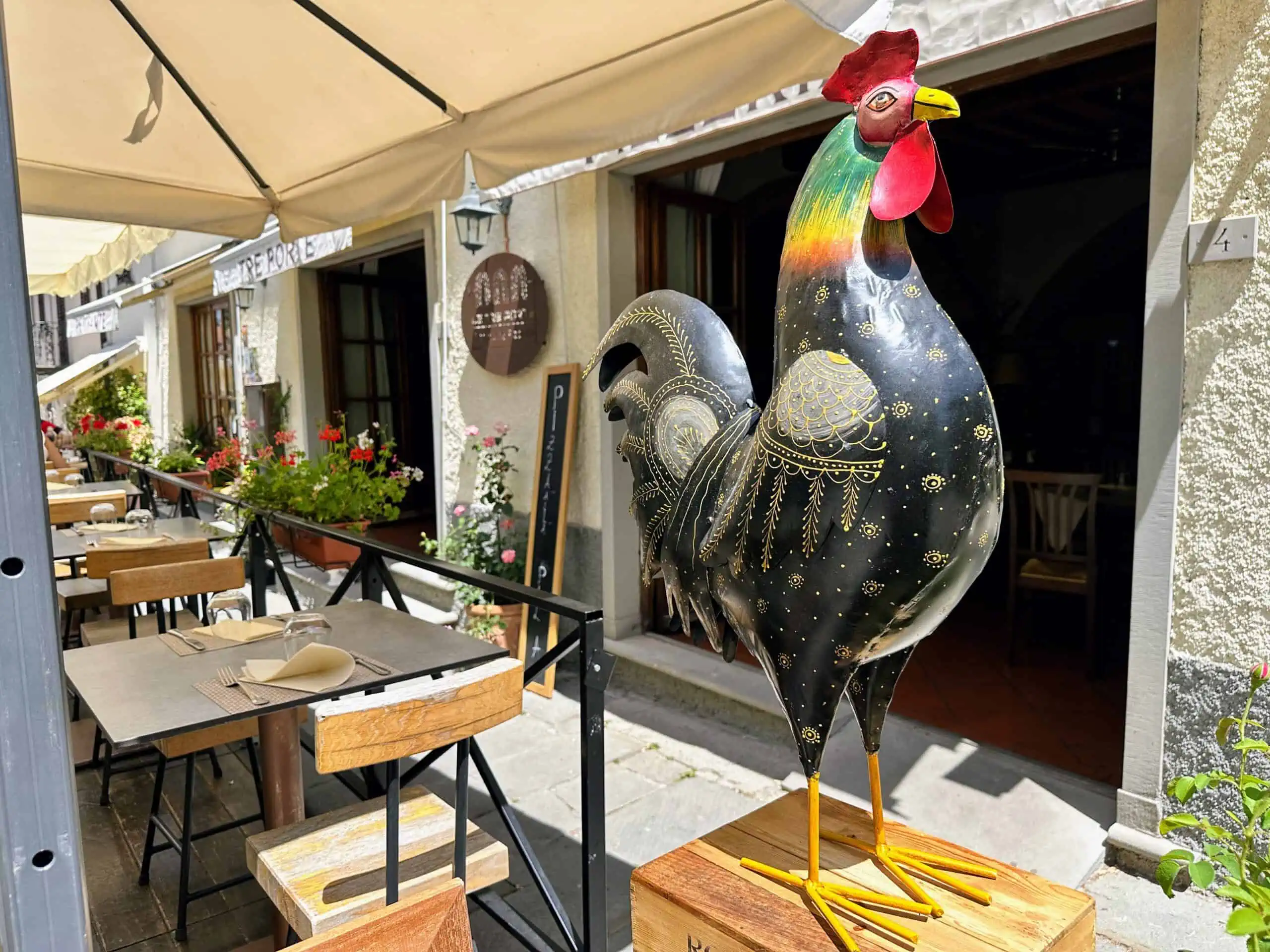Rooster sculpture on display outside a restaurant in Italy.