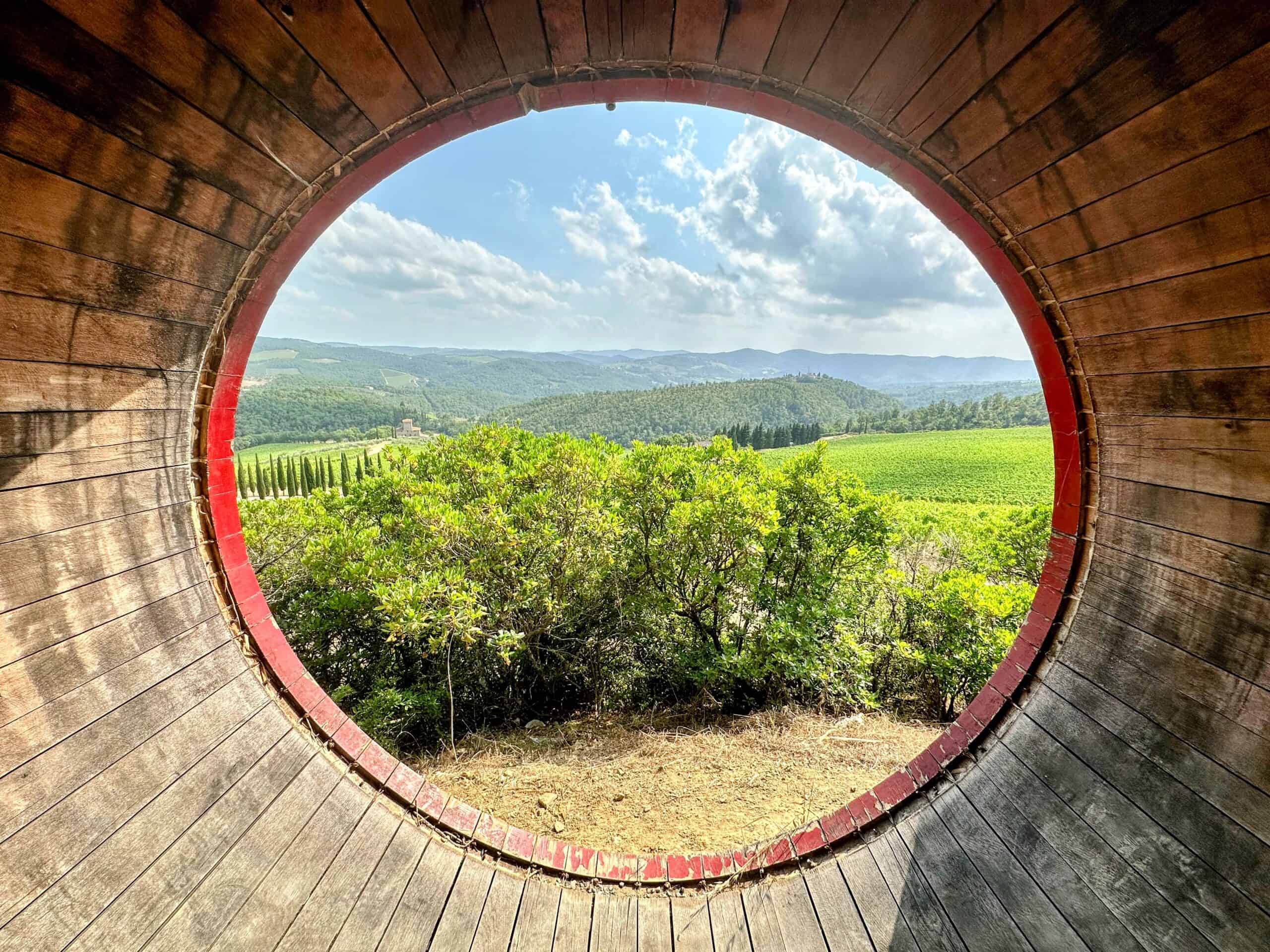 Looking through a large wine barrel at the countryside and vineyards in Chianti, Tuscany, Italy.