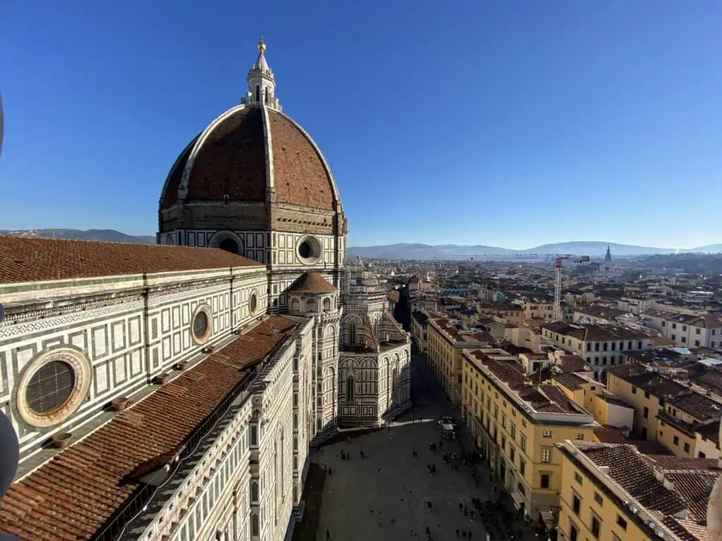 View of Florence Duomo from Giotto's bell tower on a winter day. The piazza below is almost empty.