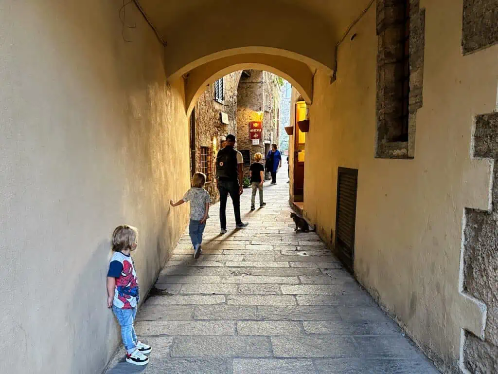 Family walking through archway in small village in Italy (Capalbio).