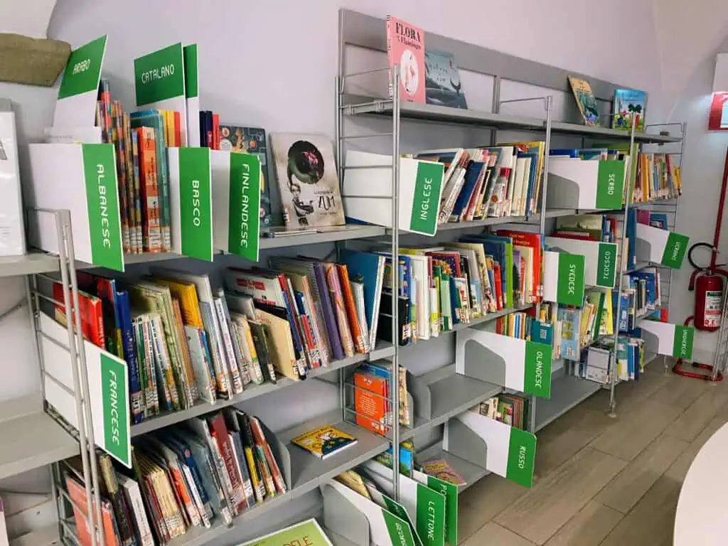 A children's bookshelf in a library with books of many different languages.