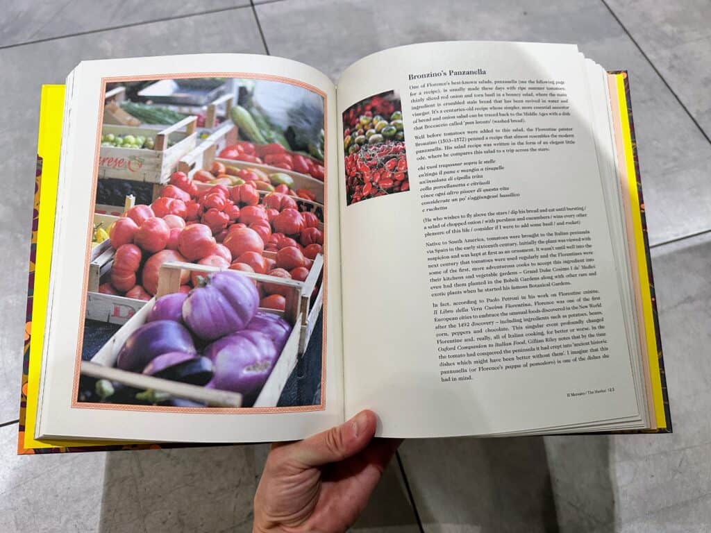 Cookbook open to page with photo of market crates of tomatoes and eggplants. Opposite page has text.