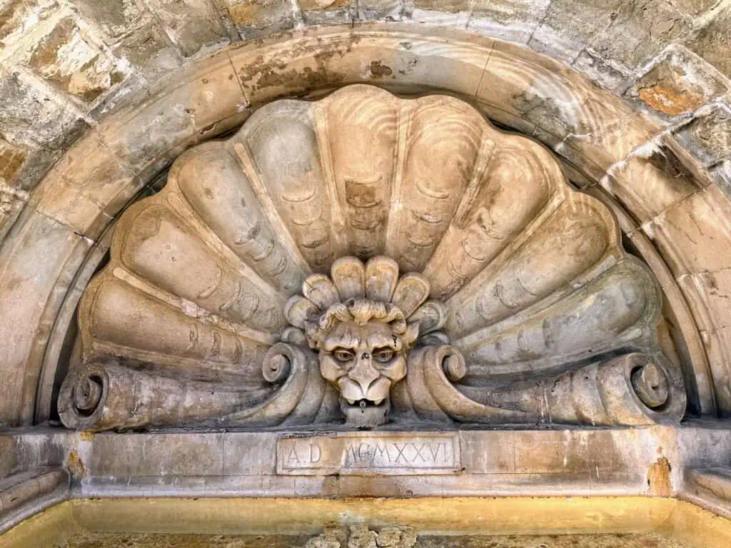 Stone fountain with gargoyle above the water in Radda in Chianti, Tuscany.