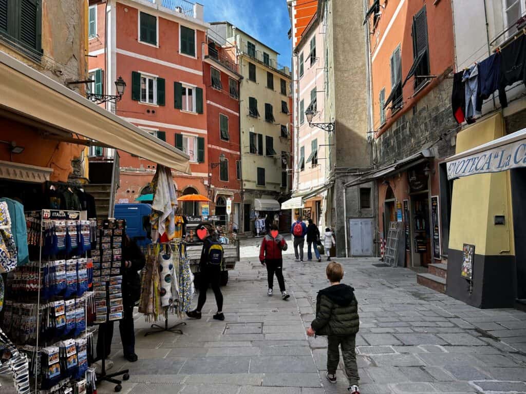 Boy walks down stone street in Vernazza, Italy.