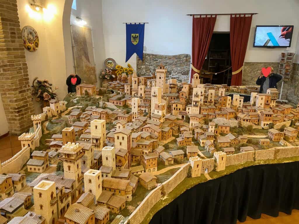 Boys look at mini reproduction of San Gimignano inside a museum.