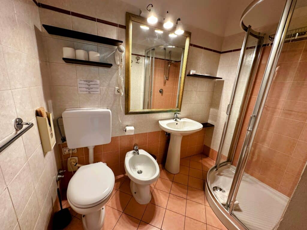Bathroom with orange and cream colored tiles in an apartment in Florence, Italy.