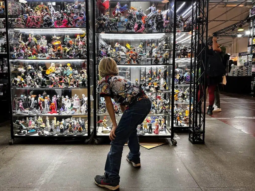 Boy looks at an anime display behind glass at the Lucca Comics and Games festival in Italy.
